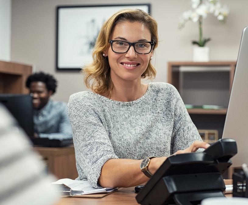 vrouw achter telefoon en computer