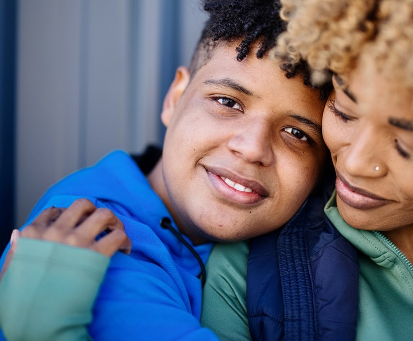 Zoon en moeder houden elkaar liefdevol vast