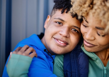 Zoon en moeder houden elkaar liefdevol vast